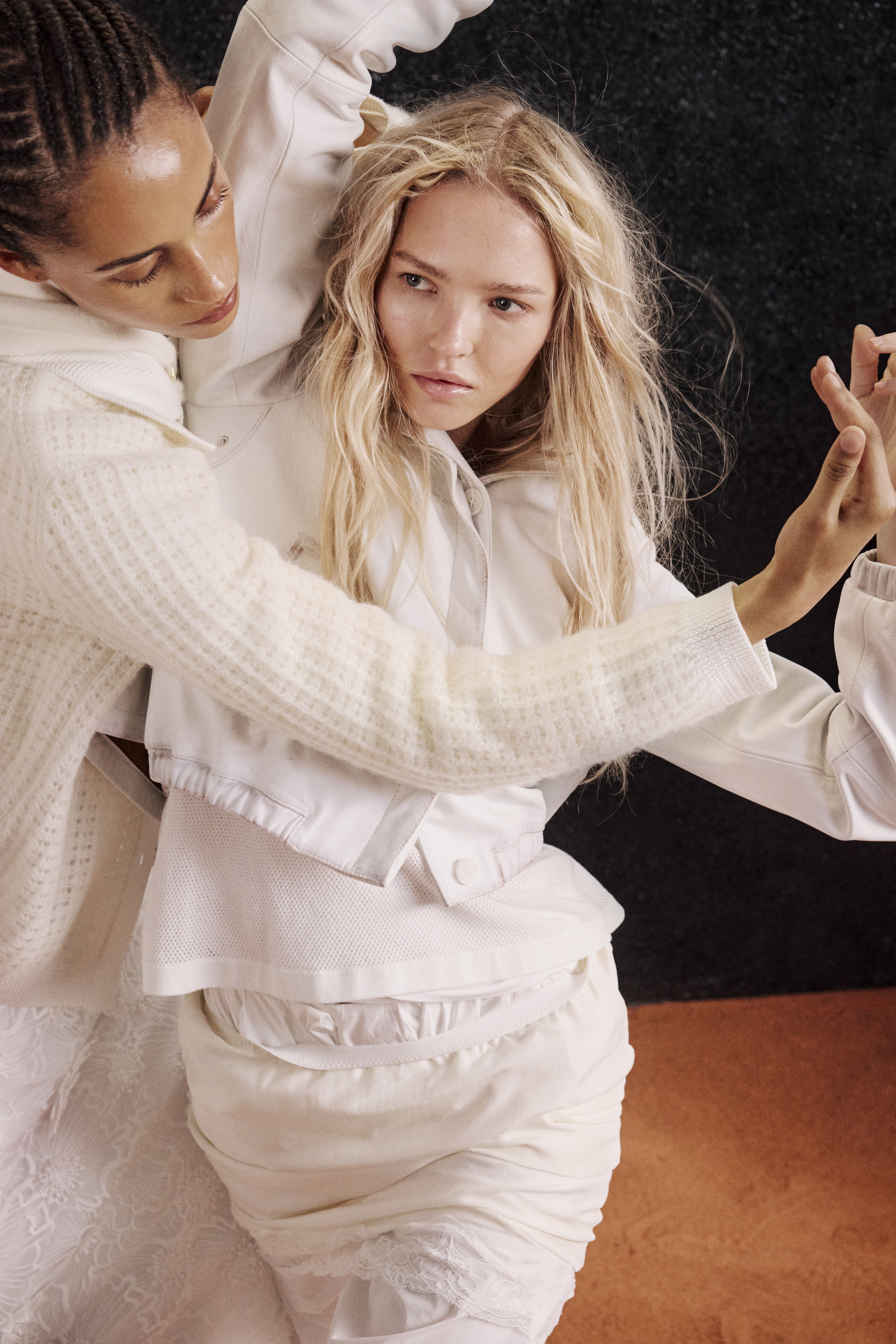 two women wearing white clothes like white skirts and a leather jacket and a knit cardigan