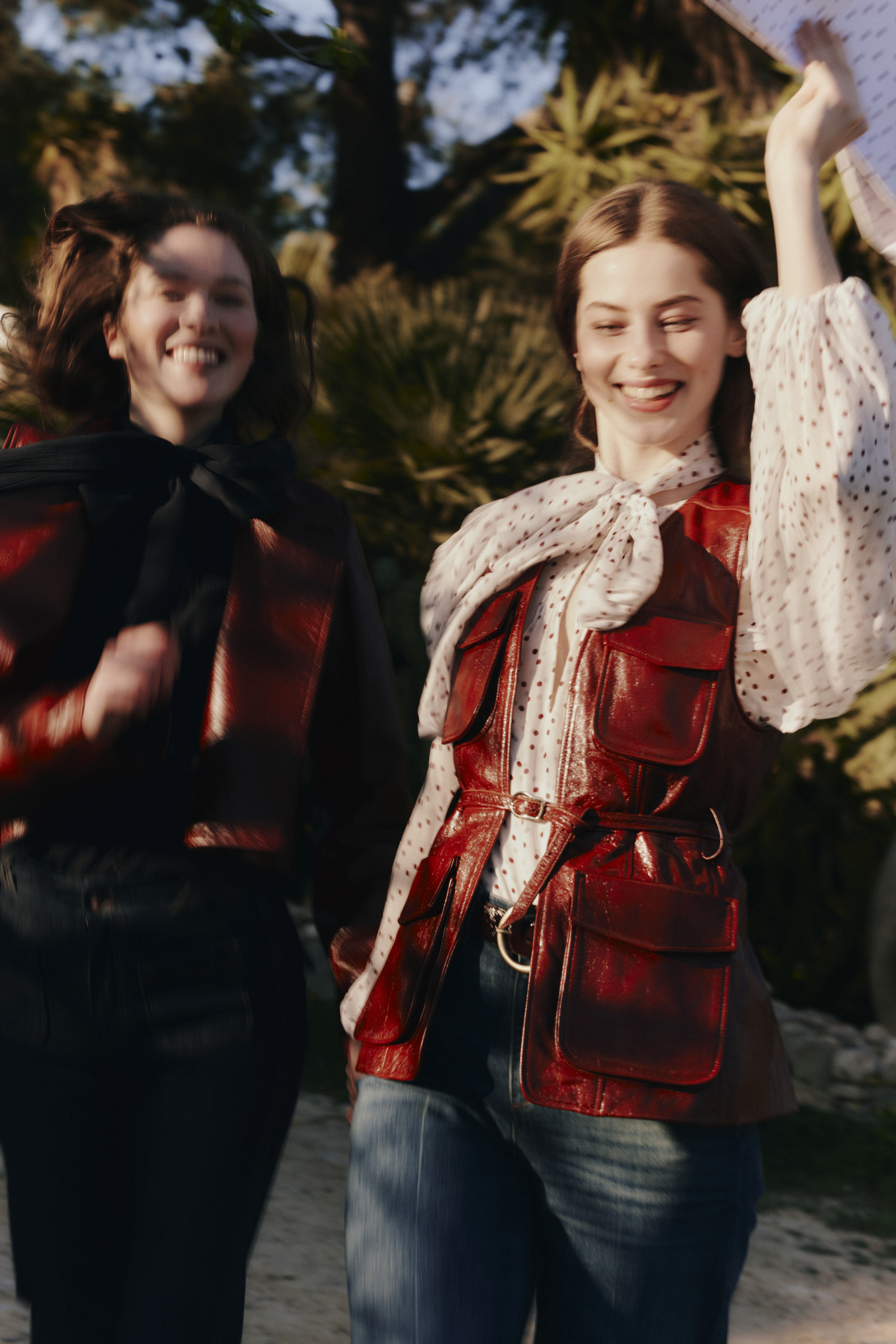 Two Models running and smiling while wearing DOROTHEE SCHUMACHER leather models and a polka dot blouse
