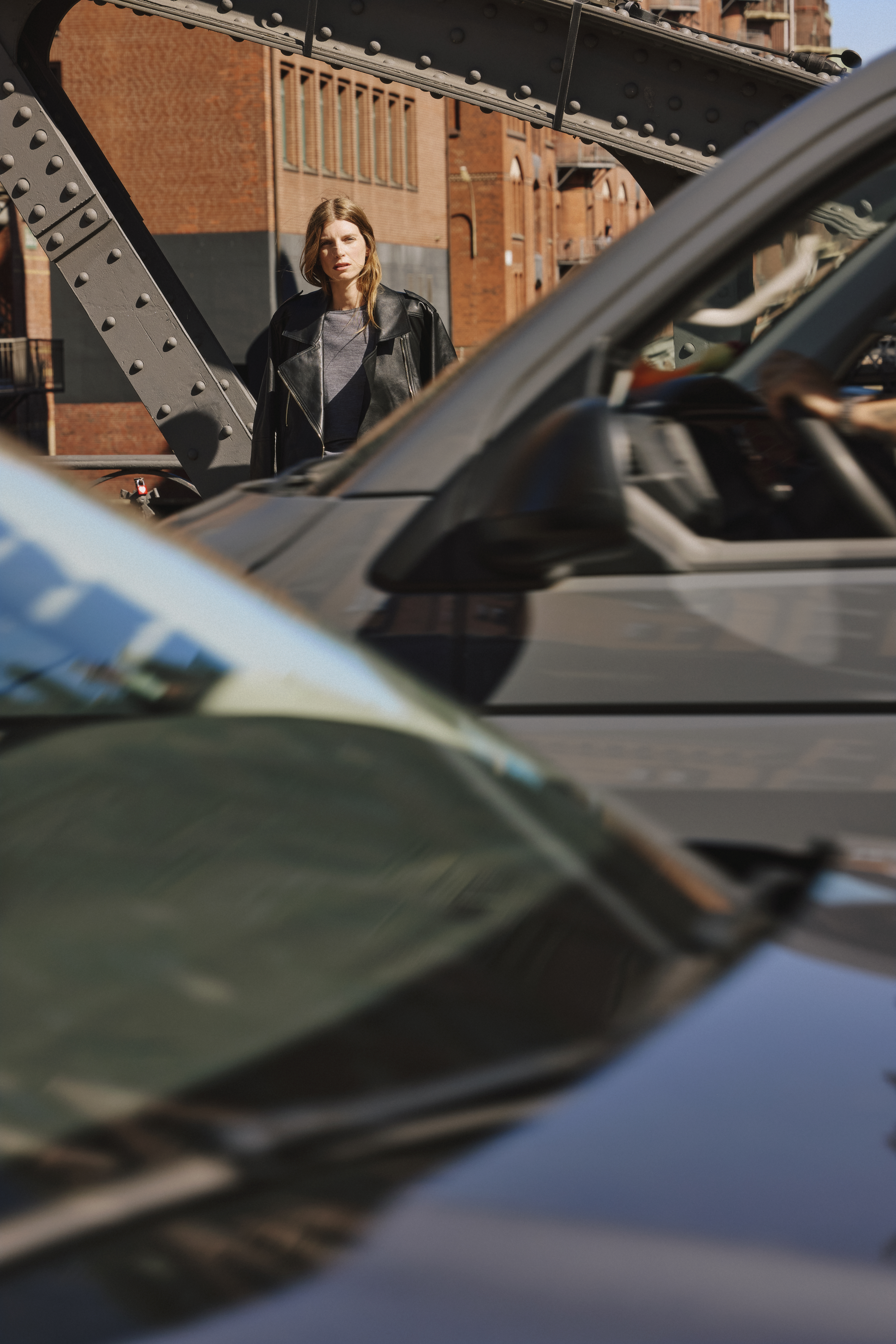 woman wearing a black leather jacket and a grey sweater with a blue jeans 