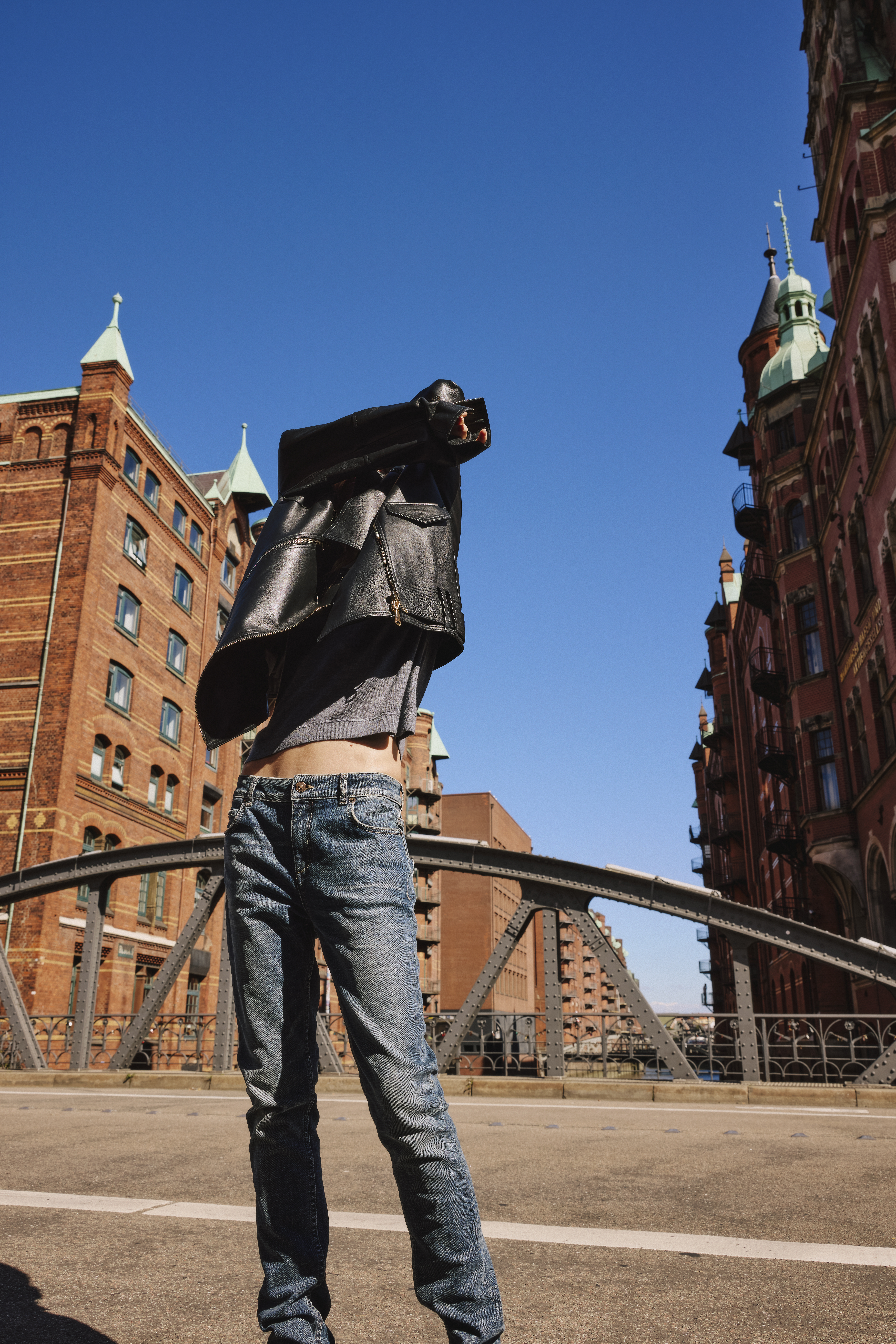 woman wearing a black leather jacket and a grey sweater with a blue jeans 