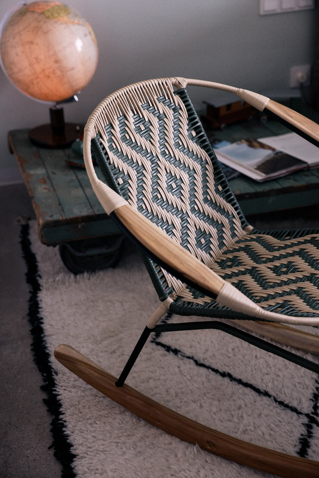 Detailshot olive colored woven rocking chair
