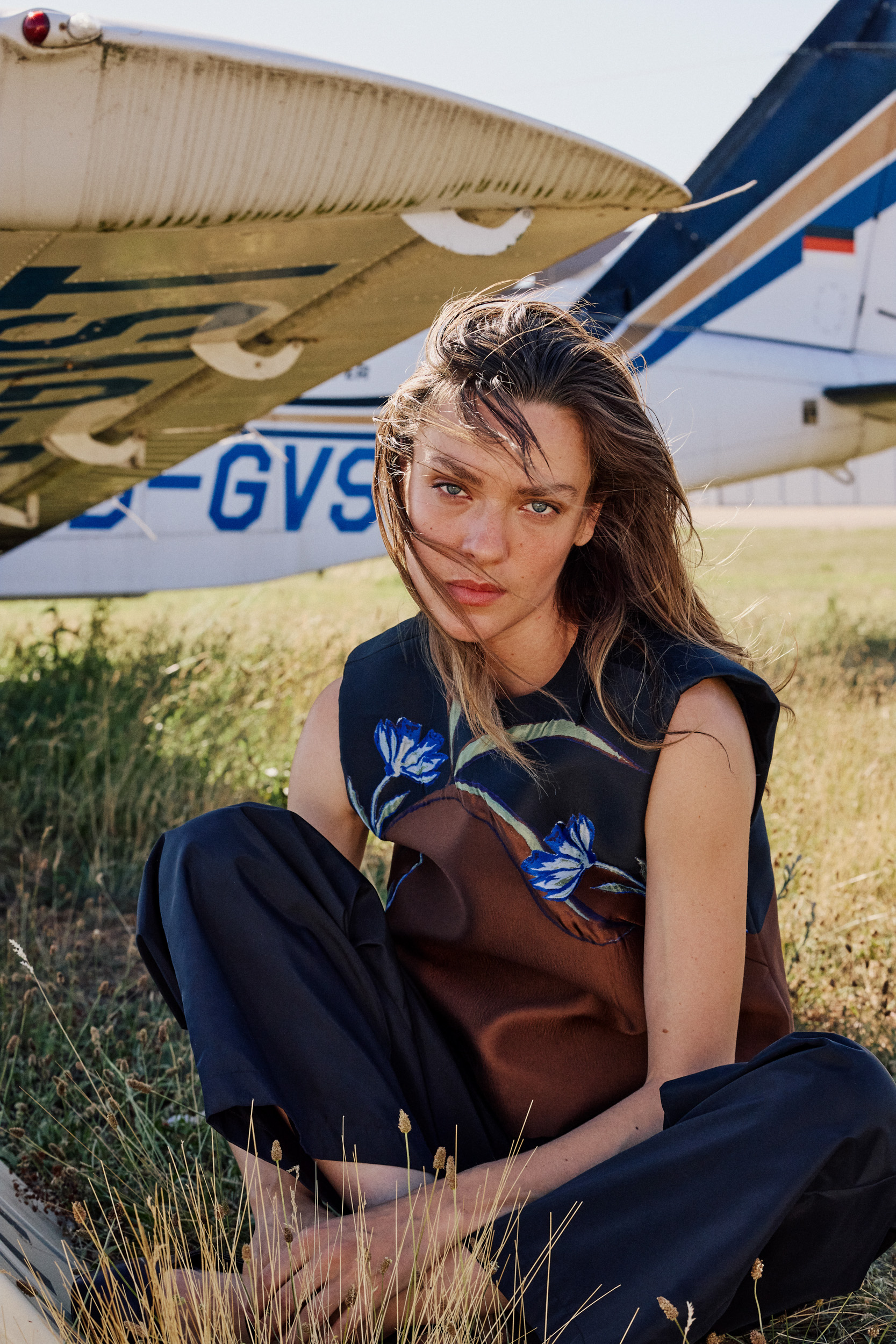 female model standing next to airplane