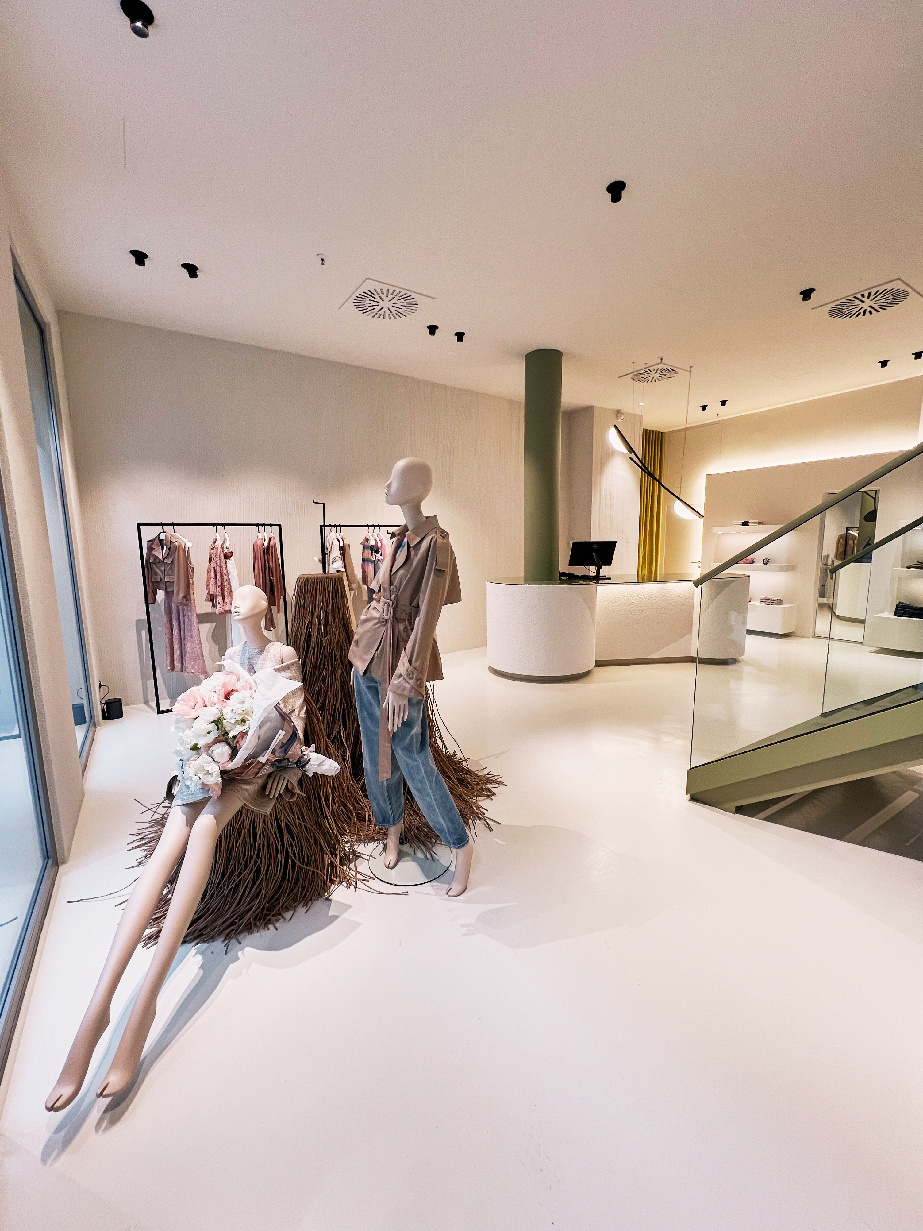 Großzügiger, heller Innenraum des Dorothee Schumacher Stores mit modernen Kleiderstangen und Mannequins, die die aktuelle Kollektion präsentieren.